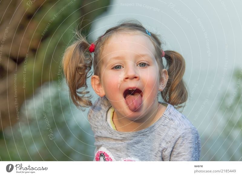 Little girl with blonde hair sticks out her tongue - a Royalty Free Stock  Photo from Photocase