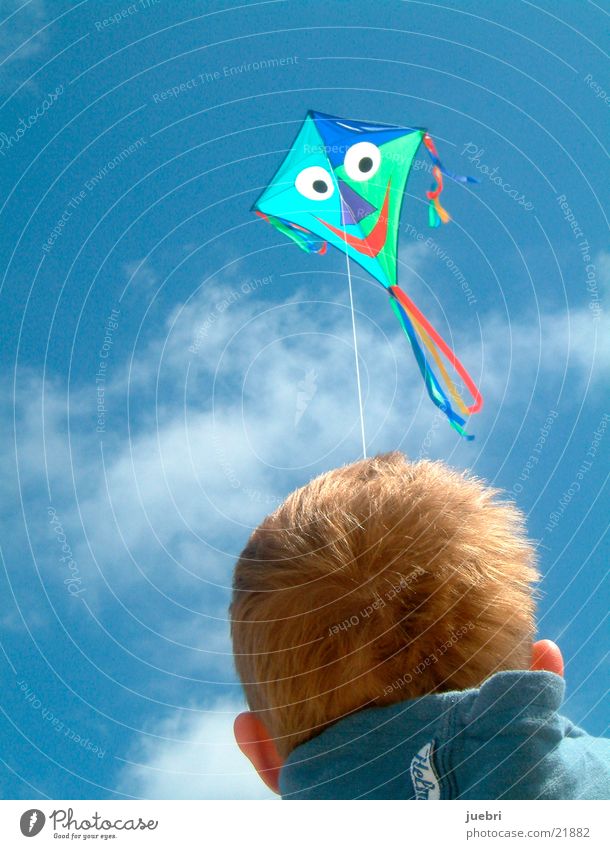 Child flying kites Colour photo Exterior shot Close-up Copy Space left Copy Space top Day Rear view Forward Sun Sky Clouds Wind North Sea Blue Brown Red