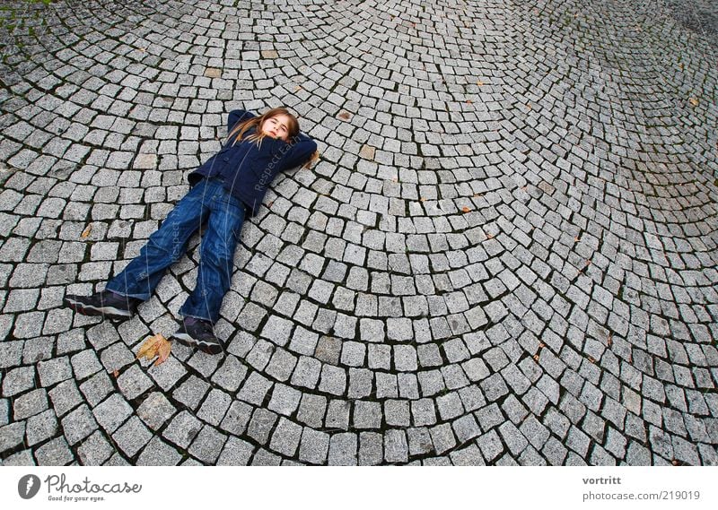 The girl with the long legs Human being Child Girl Infancy 1 3 - 8 years Places Pants Jacket Blonde Long-haired Stone Lie Blue Gray Paving stone Colour photo