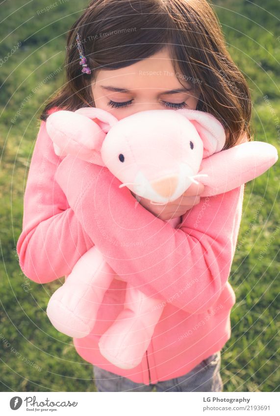 Young girl cuddles stuffy Happy Playing Sun Easter Human being Woman Adults Hand Grass Toys Doll Teddy bear Embrace Cute Clean Green Pink Emotions Safety