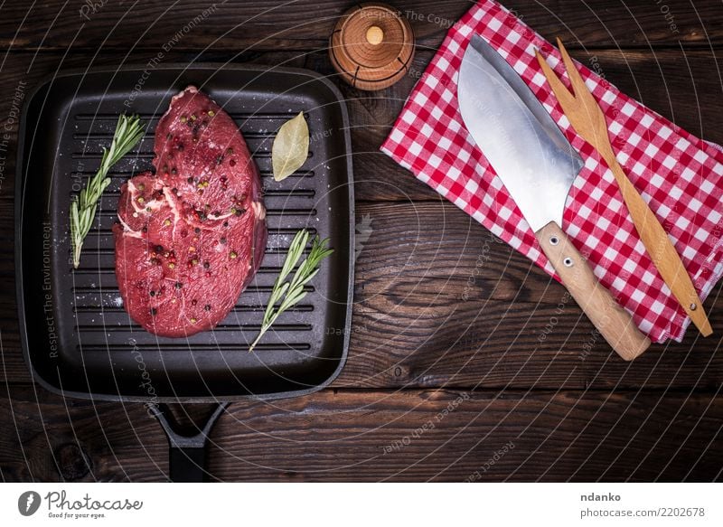 raw beef steak with spices Food Meat Herbs and spices Dinner Knives Fork Table Kitchen Wood Eating Fresh Green Red frying pan knife napkin Meal pepper Beef Chop
