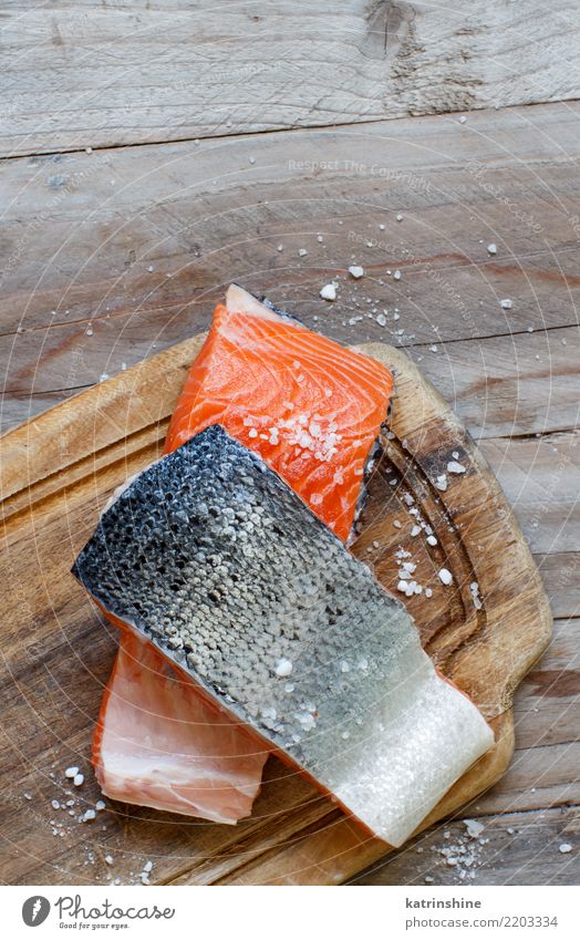 Fresh raw salmon on a wooden cutting board Fish Nutrition Eating Dinner Diet Table Above Red background cooking fillet food healthy Ingredients Meal Portion