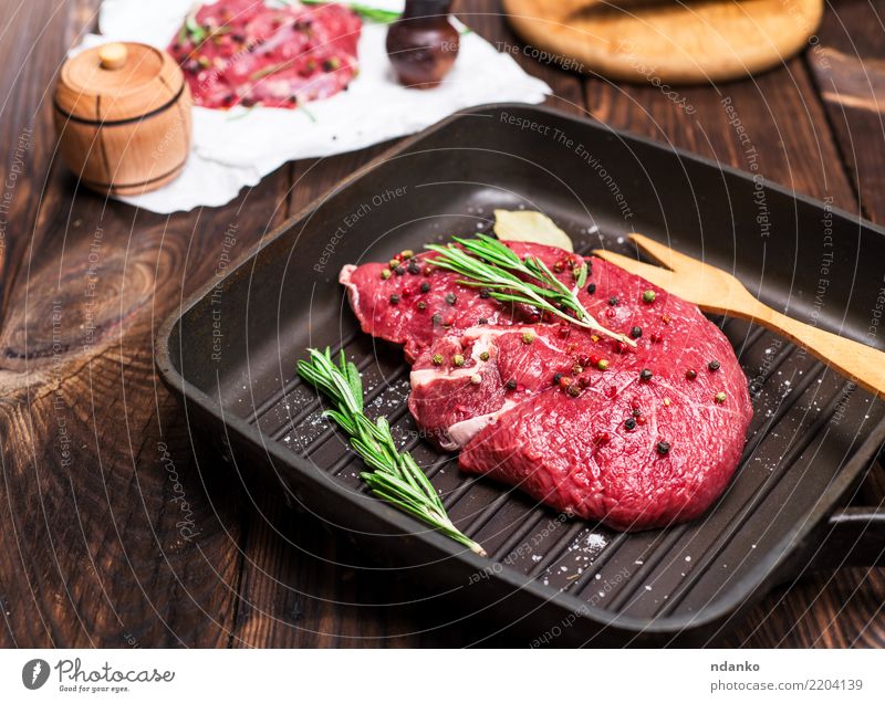 raw beef steak in spices Meat Herbs and spices Dinner Fork Table Kitchen Cow Paper Wood Eating Fresh Green Red background Beef Blood board butcher Chop close