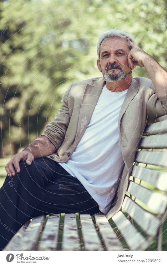 Portrait of a pensive mature man sitting on a bench in an urban park. Lifestyle Happy Retirement Human being Masculine Man Adults Male senior 1 45 - 60 years