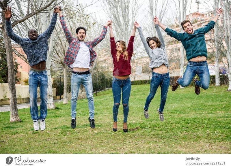 Group of multi-ethnic young people jumping together Lifestyle Joy Human being Woman Adults Man Friendship 5 18 - 30 years Youth (Young adults) Park Street