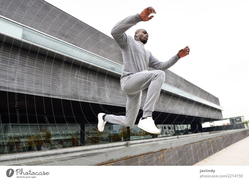 Black man jumping in urban background. Lifestyle Sports Jogging Human being Man Adults Street Fitness Jump running african movement forward young action health