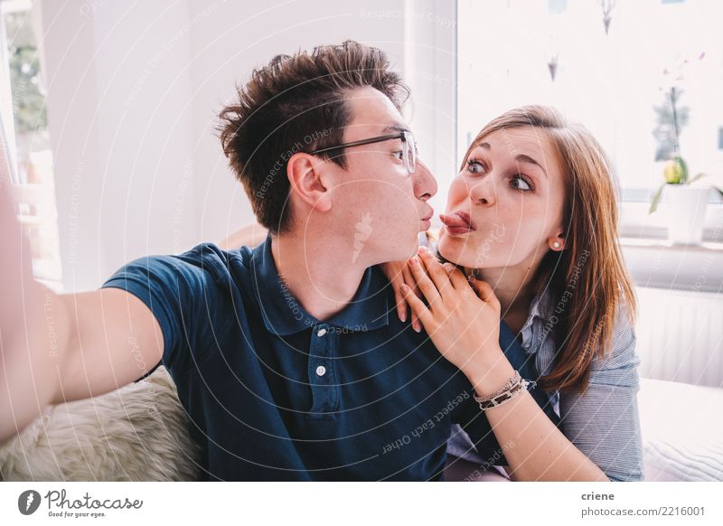 Mixed Race couple taking funny selfie with phone together Joy Face Leisure and hobbies House (Residential Structure) Living room Telephone Camera Technology