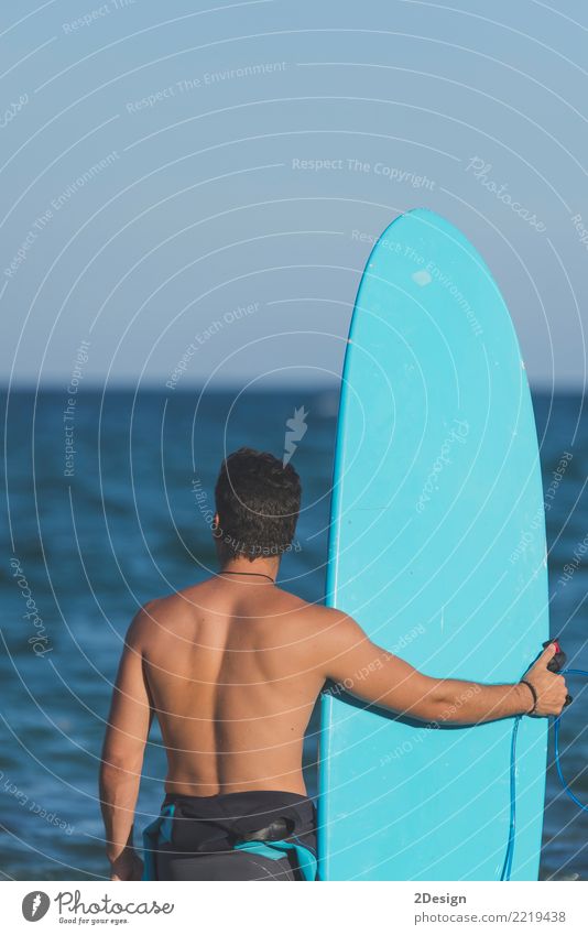 Surfer holding his surfboard at the beach Lifestyle Joy Vacation & Travel Summer Beach Ocean Waves Sports Man Adults Youth (Young adults) Sky Clouds Coast