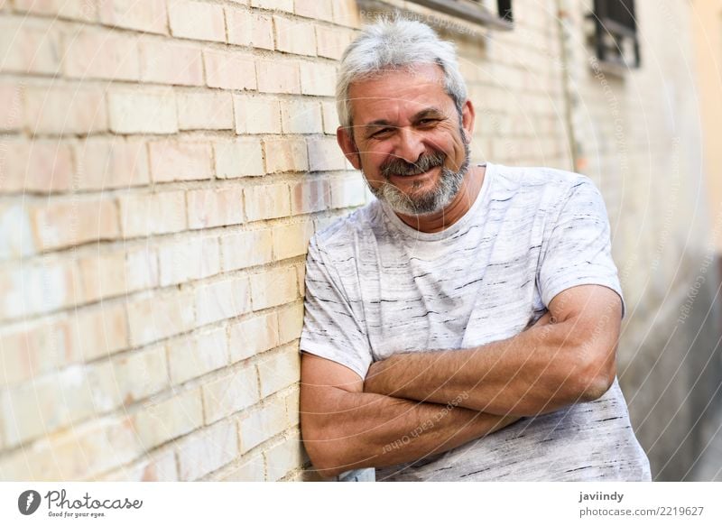 Mature man smiling at camera in urban background. Lifestyle Happy Human being Man Adults Male senior 1 45 - 60 years Street Clothing Beard Old Smiling White