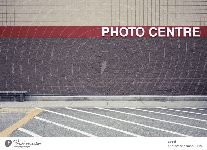 PHOTO CENTRE Wall (barrier) Wall (building) Facade Parking lot Street Road sign Bench Characters Signs and labeling Line Brown Yellow Gray Red White