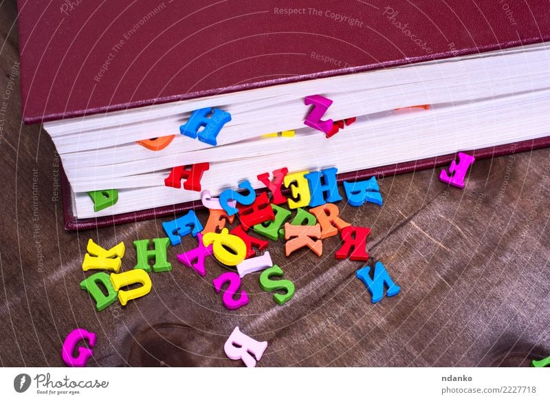 multicolored letters of the English alphabet Table Book Wood Study Blue Brown Pink Red Information colorful closed cover knowledge Colour photo Close-up