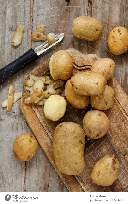 Raw potatoes with a vegetable peeler top view Food Vegetable Nutrition Vegetarian diet Skin Group Wood Fresh Brown agriculture carbohydrate cook cooking Harvest