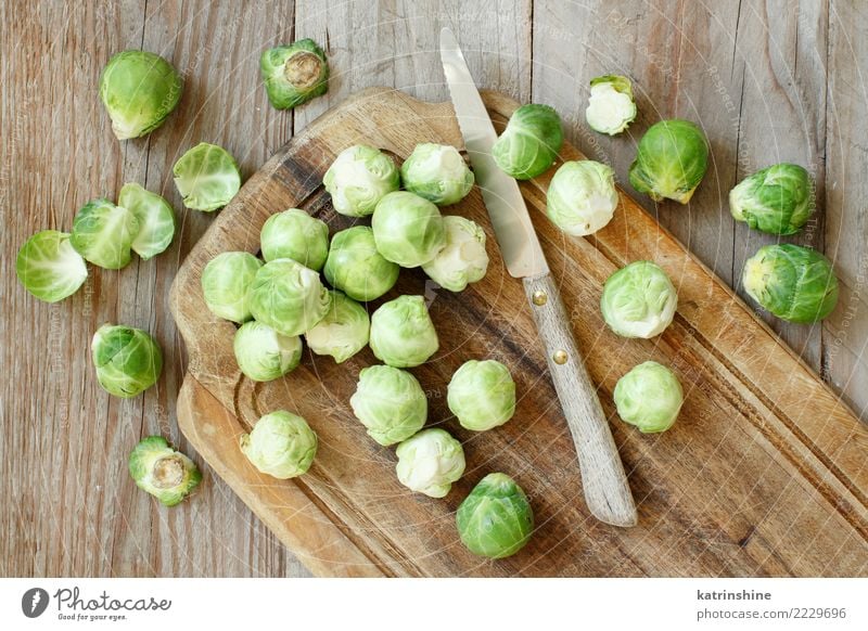 Brussels sprouts on a wooden board with a knife Vegetable Nutrition Vegetarian diet Diet Table Gastronomy Fresh Bright Natural Retro Brown Green agriculture