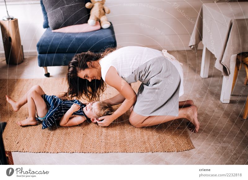 Happy Mother tickling her cute toddler son at home Lifestyle Joy Playing Living room Kitchen Child Human being Toddler Parents Adults Smiling Laughter Love