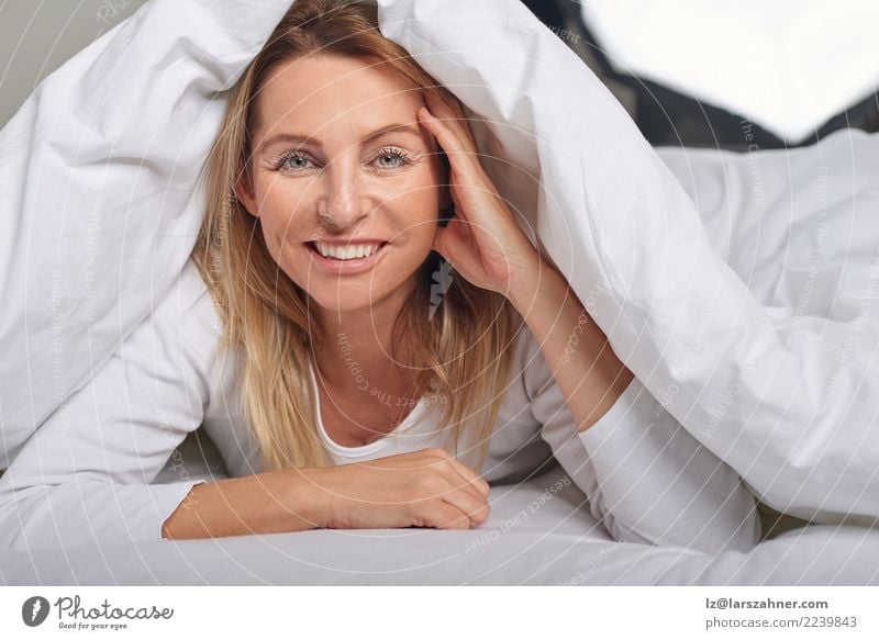 Beautiful middle-aged woman under sheets Happy Skin Face Relaxation Bedroom Woman Adults 1 Human being 45 - 60 years Blonde Smiling Sleep Happiness Under Soft