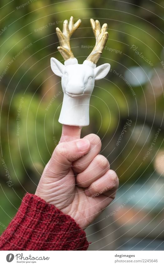 Statue of white deer on finger. Design Vacation & Travel Winter Decoration Christmas & Advent Hand Fingers Nature Animal Sweater Toys Cute Wild Gold Red White