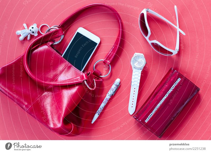 Red and white things pulled out of red handbag Lifestyle Elegant Style Contentment Telephone Cellphone PDA Accessory Pen Observe Above glasses Handbag key