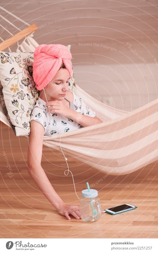Teenage girl with towel on head using mobile phone sitting in hammock at home Lifestyle Shopping Child Telephone Cellphone PDA Technology Human being Girl