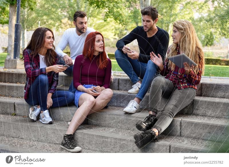Group of young people with smartphone and tablet computers outdoors Lifestyle Joy Happy Beautiful Telephone Computer Technology Internet Woman Adults Man