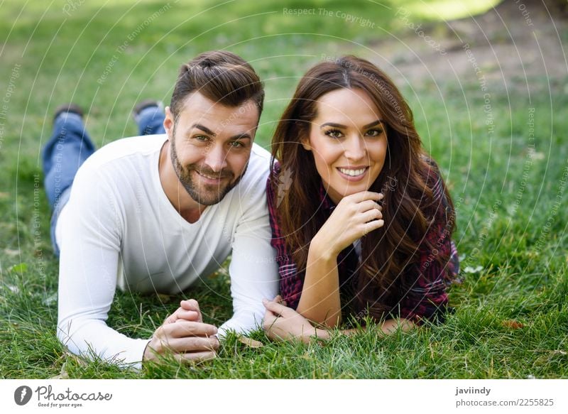 Beautiful young couple laying on grass in an urban park Lifestyle Joy Happy Summer Human being Masculine Feminine Young woman Youth (Young adults) Young man