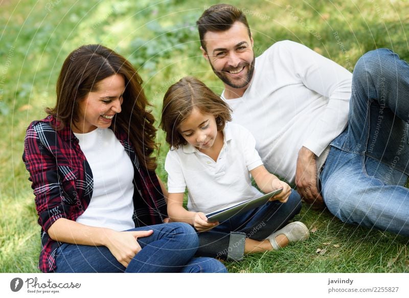 Happy family in a urban park playing with tablet compute Lifestyle Joy Beautiful Playing Summer Child Computer Technology Human being Masculine Feminine Girl
