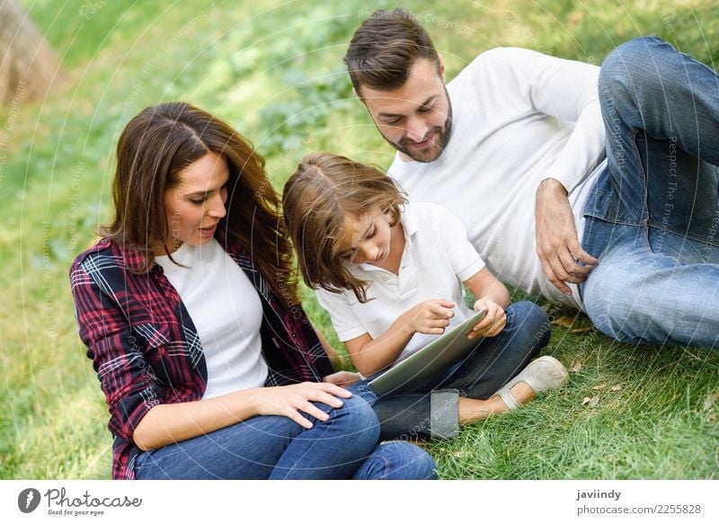 Happy family in a urban park playing with tablet computer Lifestyle Joy Beautiful Playing Summer Child Computer Technology Human being Girl Young woman