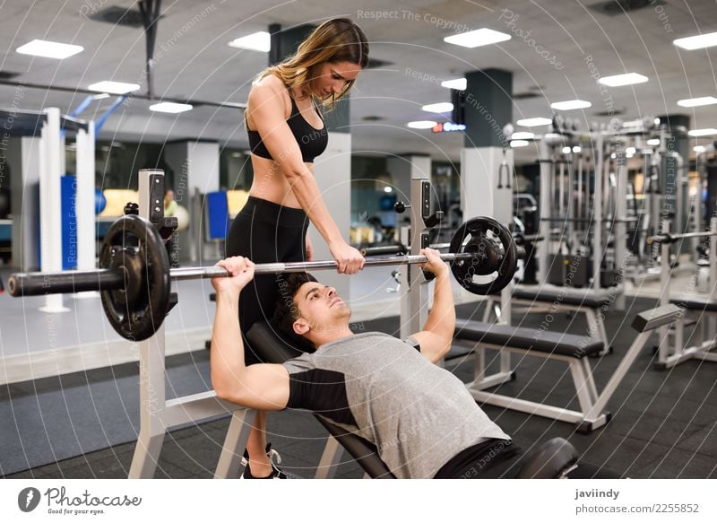 Female personal trainer helping a young man lift weights Lifestyle Body Sports Human being Masculine Feminine Young woman Youth (Young adults) Young man Woman