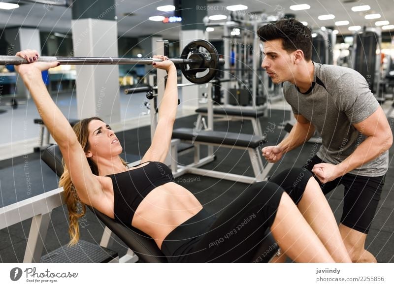Personal trainer motivating a young woman lift weights Lifestyle Body Sports Human being Masculine Feminine Young woman Youth (Young adults) Young man Woman