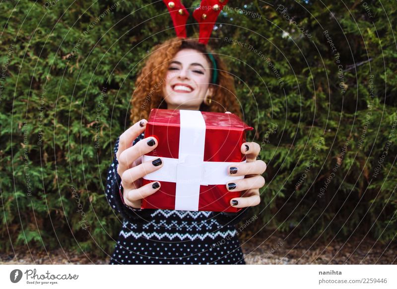 Young woman holding a christmas gift Lifestyle Shopping Style Joy Feasts & Celebrations Christmas & Advent New Year's Eve Human being Feminine
