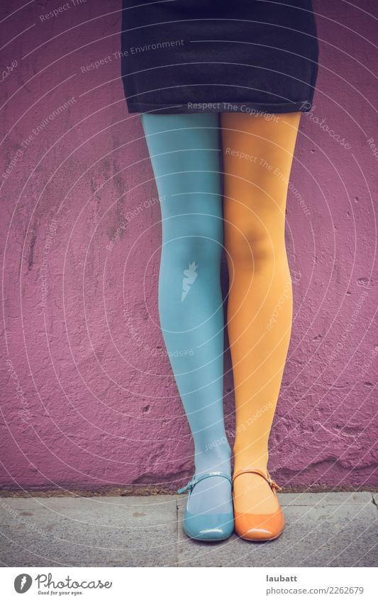 Female legs in coloured tights and Mary Jane shoes, each leg has a different color: one sky blue, another yellow Joy Beautiful Dance Young woman