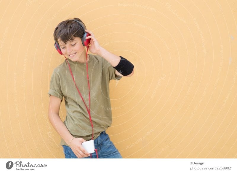 Handsome teen wearing a green T-shirt listening to music Lifestyle Style Joy Happy Music Telephone Headset PDA Technology Human being Boy (child) Man Adults