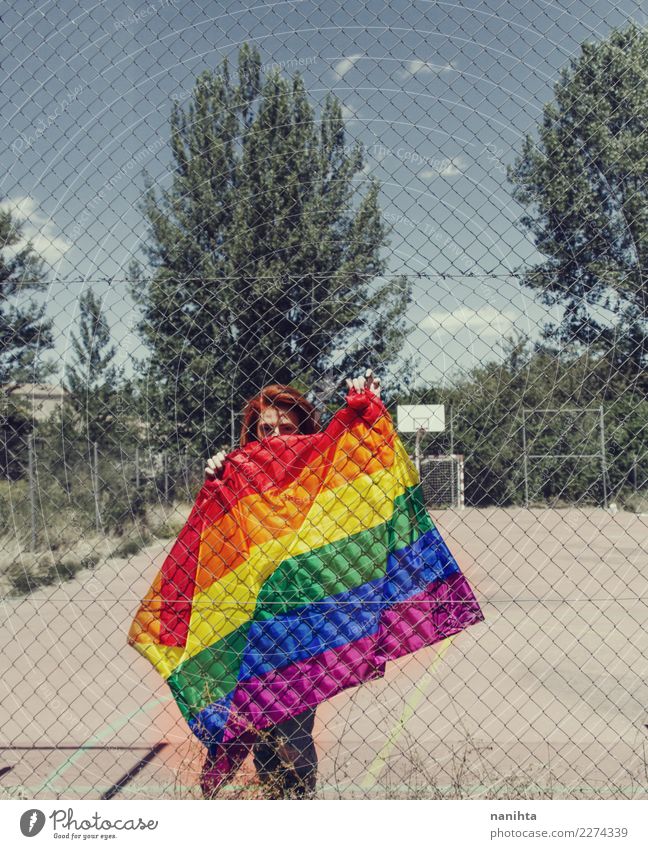Young woman holding a rainbow flag behind a fence Lifestyle Style Design Education Adult Education Schoolyard Human being Feminine Homosexual