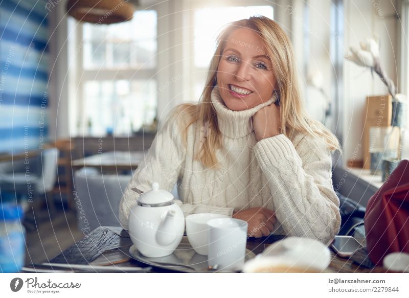 Portrait of a beautiful woman looking at camera Drinking Coffee Tea Pot Happy Beautiful Face Calm Leisure and hobbies Winter Table Woman Adults 1 Human being