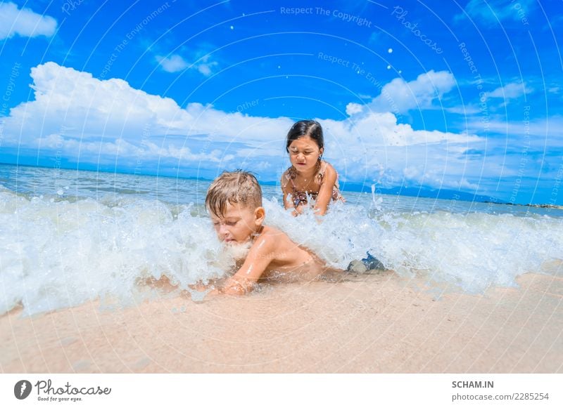 Cute kids having fun on the sunny tropical beach. Lifestyle Joy Freedom Summer Summer vacation Sun Sunbathing Beach Ocean Island Waves Child Human being Girl