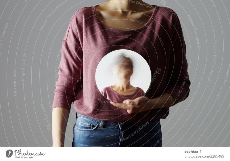 Who am I? Young woman holding a round mirror in front of her body. The mirror is showing her blurred face. mental illness depression confusion Anorexia