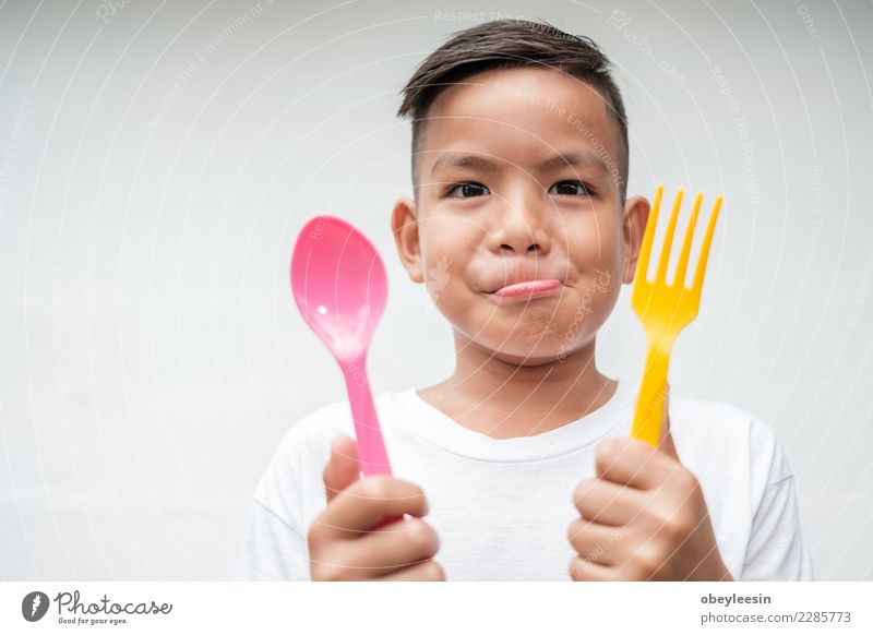 young asian boy with foek and spoon Vegetable Nutrition Eating Lunch Dinner Vegetarian diet Diet Bottle Lifestyle Happy Beautiful Face Leisure and hobbies Table