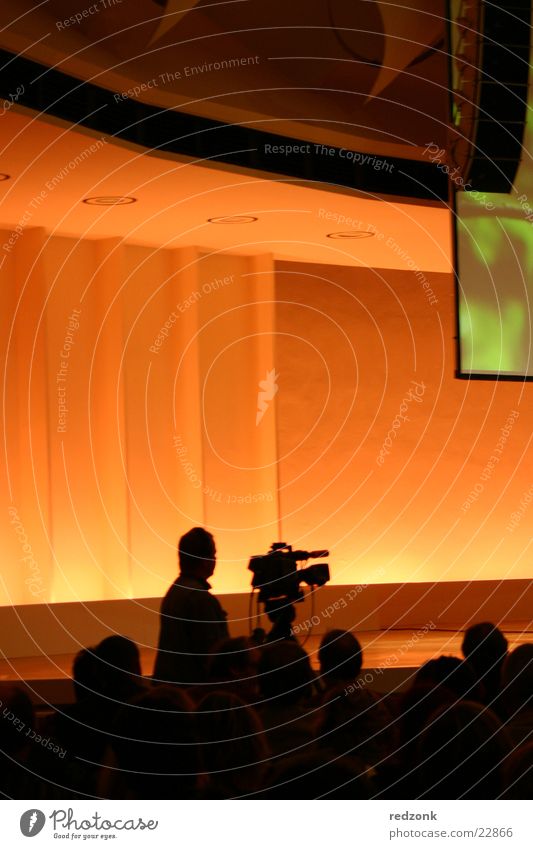 cameraman Leisure and hobbies Event Audience TV set Video camera Camera Television Film industry Esthetic Brown Camera-man Filming Communication Orange
