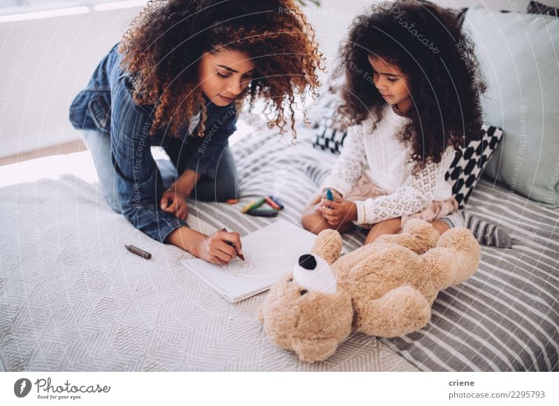 African mother helping daughter doing homework Happy Child Human being Woman Adults Parents Mother Family & Relations Infancy Art Paper Small Cute Black Colour