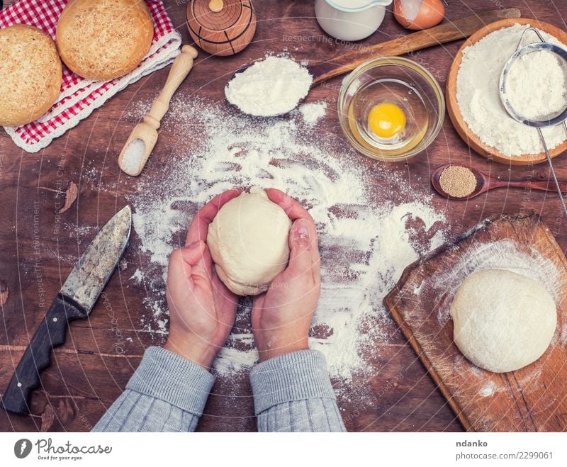 hands hold a ball of yeast dough Dough Baked goods Bread Bowl Knives Body Table Kitchen Arm Hand Sieve Wood Fresh Natural Above Brown White Yeast background