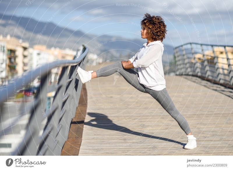 Young black woman doing stretching after running outdoors Lifestyle Beautiful Hair and hairstyles Wellness Leisure and hobbies Sports Jogging Human being