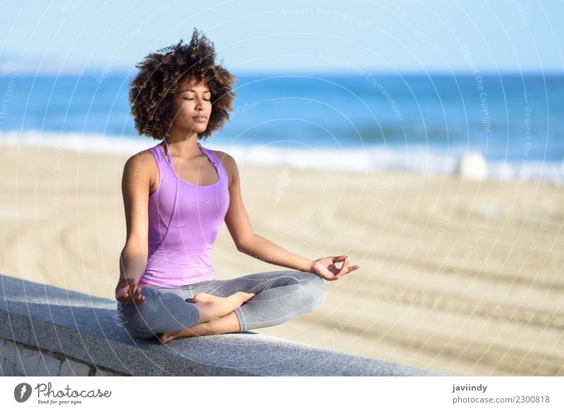 Black woman, afro hairstyle, doing yoga asana in the beach with eyes closed. Lifestyle Hair and hairstyles Wellness Relaxation Meditation Leisure and hobbies