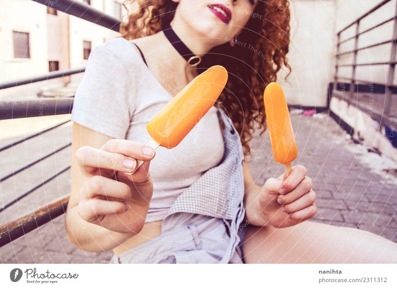 Young woman holding two orange ice creams Food Ice cream Eating Lifestyle Style Wellness Harmonious Summer Summer vacation Human being Feminine