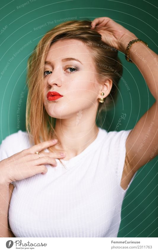 Girl with blonde hair posing in front of turquoise background Lifestyle Elegant Style Feminine Young woman Youth (Young adults) Woman Adults 1 Human being