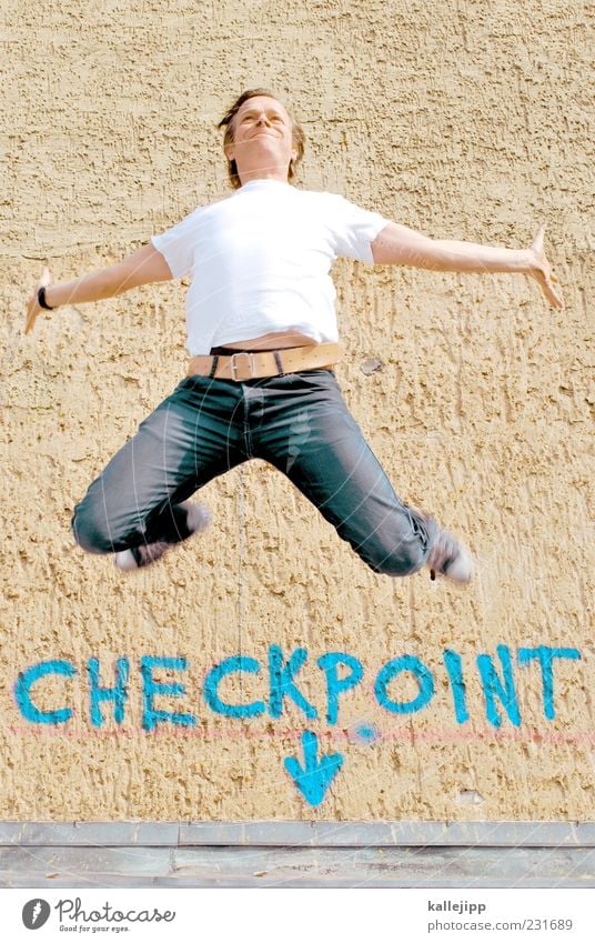 checkpoint charlie Human being Masculine Man Adults 1 30 - 45 years T-shirt Jeans Sneakers Jump Checkpoint Charlie Arrow Signs and labeling Graffiti