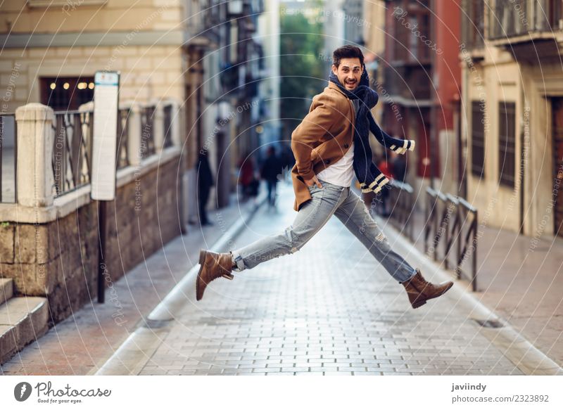Happy man jumping wearing winter clothes in the street Style Joy Winter Human being Young man Youth (Young adults) Man Adults 1 18 - 30 years Autumn Street
