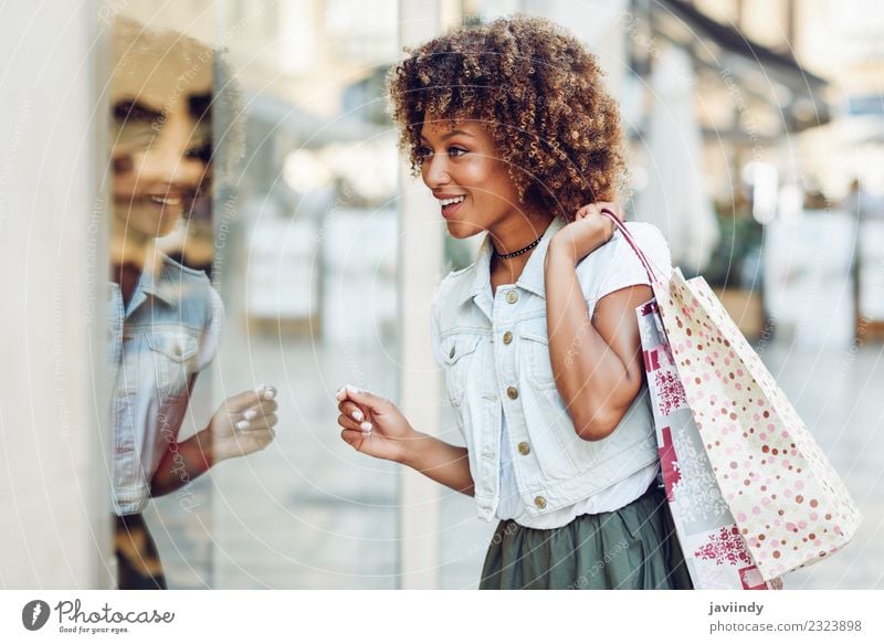 Young black woman in front of a shop window in a shopping street Lifestyle Shopping Style Hair and hairstyles Human being Feminine Young woman