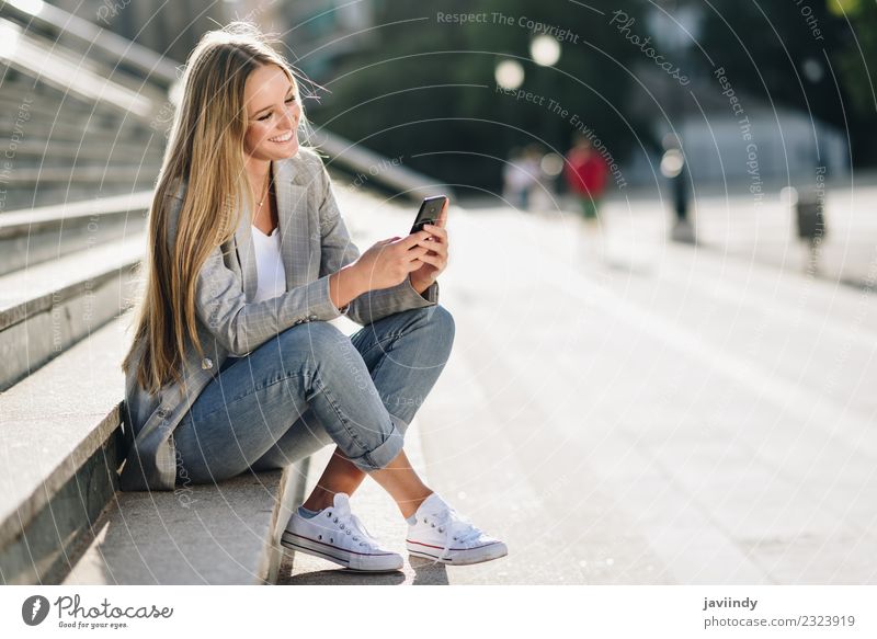 Beautiful young caucasian woman looking at her smartphone and smiling in urban background. Lifestyle Style Happy Hair and hairstyles Telephone PDA Human being