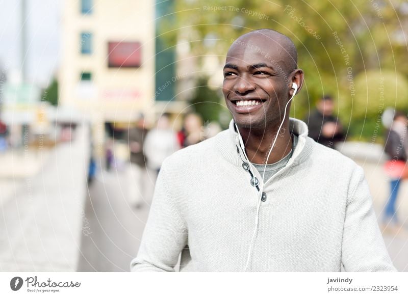 Smiling black man with earphones in the street Lifestyle Happy Beautiful Face Human being Masculine Young man Youth (Young adults) Man Adults 1 18 - 30 years