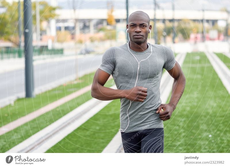 Black man running and listening to music in urban background Lifestyle Body Sports Jogging Headset Human being Masculine Young man Youth (Young adults) Man