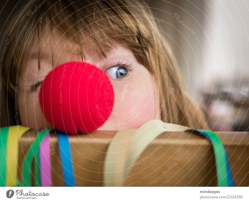 Blonde girl peeping out from behind a red clown nose. Joy Playing Carnival Infancy 1 Human being 3 - 8 years Child Circus Party Paper streamers Nose